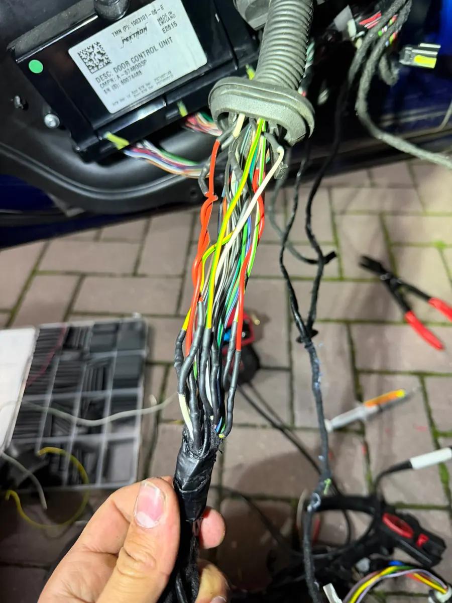 Kabelboom van een Tesla Model S tijdens het herstel, met de deurmodule erboven